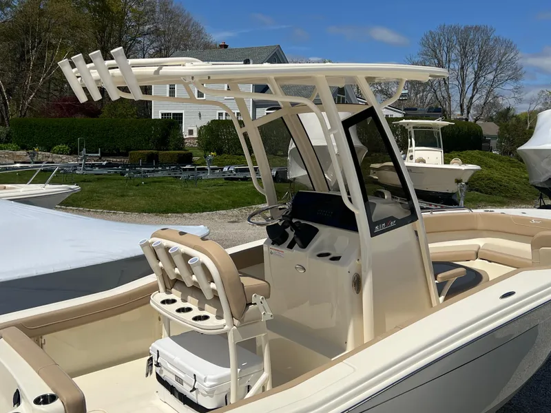 Slide: The Image of 2024 Scout 215 XSF boat with center console and T-top in a marina. - 4