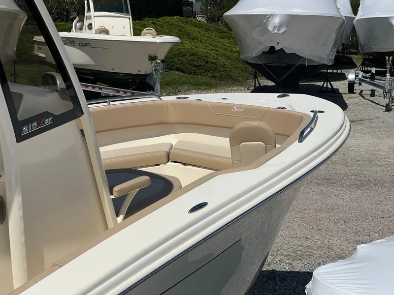 Slide: The Image of 2024 Scout 215 XSF boat with beige seating, displayed outdoors. - 5