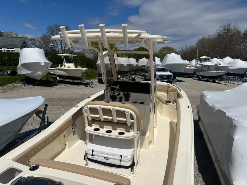 Slide: The Image of 2024 Scout 215 XSF boat with center console and T-top in a marina. - 6