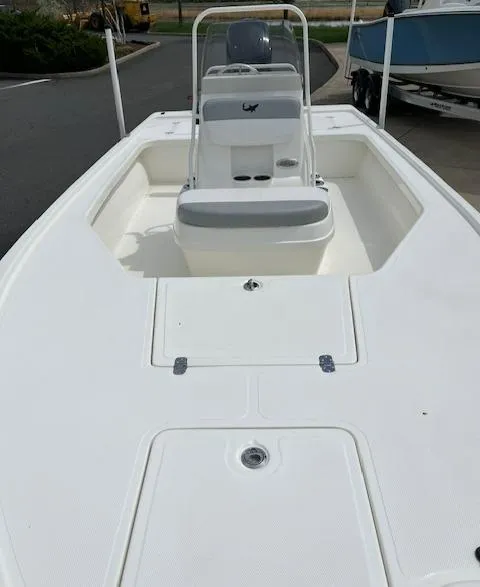 Slide: The Image of 2024 Mako 18 LTS boat with center console and seating, docked. - 2