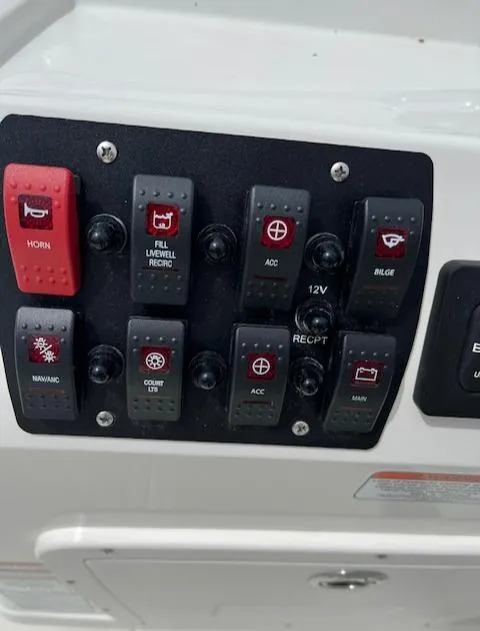 Slide: The Image of Control panel of a 2024 Mako 18 LTS boat with various switches. - 6