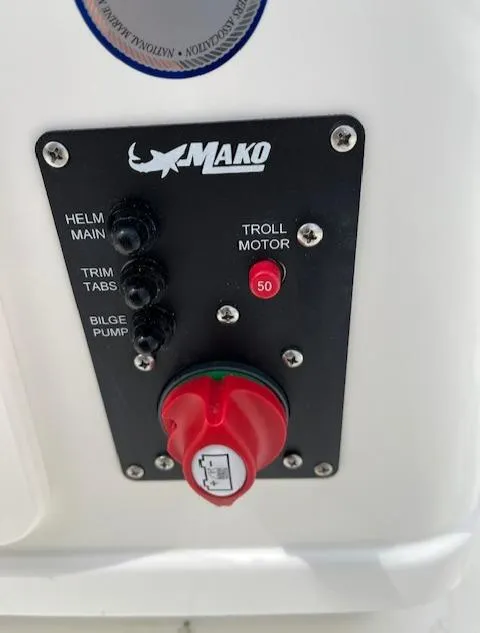 Slide: The Image of Control panel of a 2024 Mako 18 LTS boat with helm, trim tabs, and bilge pump switches. - 7