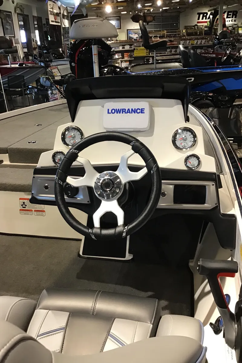 Slide: The Image of 2024 Nitro Z20 boat dashboard with Lowrance electronics and steering wheel. - 2
