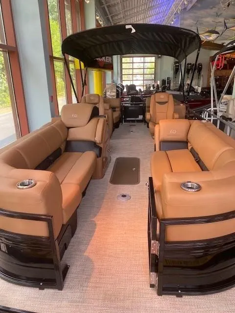 Slide: The Image of 2024 Regency 230 LE3 pontoon boat interior with tan seating and black accents. - 1