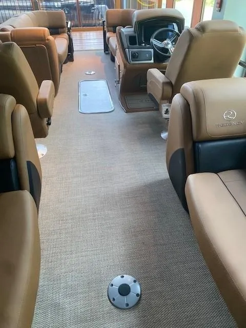 Slide: The Image of 2024 Regency 230 LE3 boat interior with tan leather seats and modern dashboard. - 2