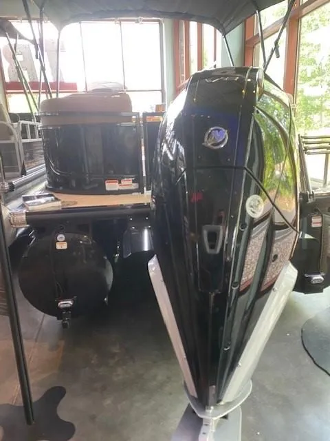 Slide: The Image of 2024 Regency 230 LE3 boat with powerful outboard motor in showroom. - 3