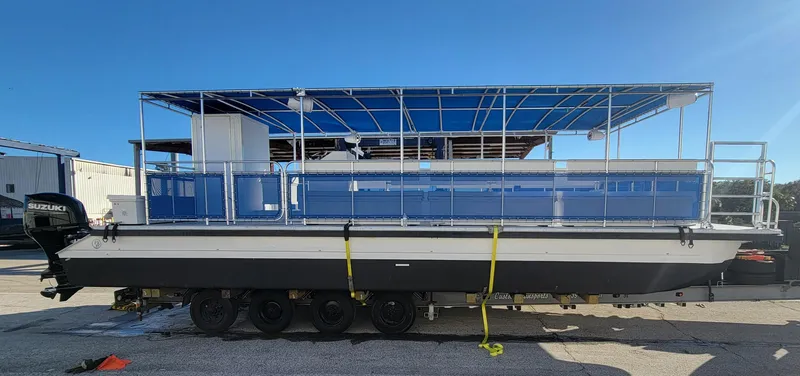 Slide: The Image of 2024 A&M Manufacturing BullDog 34 pontoon boat with blue canopy on trailer. - 19