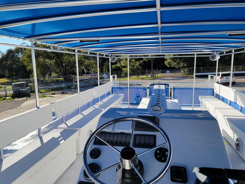Slide: The Image of 2024 A&M Manufacturing BullDog 34 boat interior with blue canopy and steering wheel. - 24