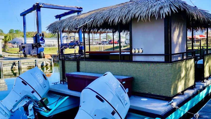 Slide: The Image of 2024 A&M Manufacturing BullDog 34 houseboat with dual outboard motors docked at a marina. - 4