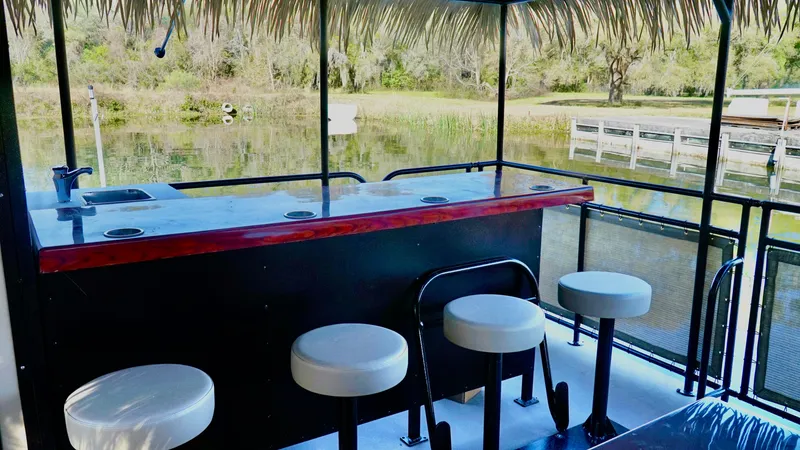 Slide: The Image of Outdoor bar area on A&M Manufacturing BullDog 34 boat, 2024 model, with stools and scenic water view. - 5