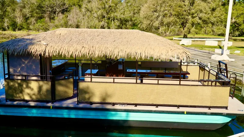 Slide: The Image of 2024 A&M Manufacturing BullDog 34 pontoon boat with a thatched roof. - 6