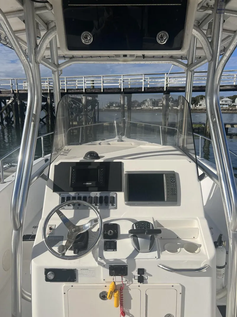 Slide: The Image of 2005 Cobia 314 Center Console boat dashboard with steering wheel and navigation equipment. - 10