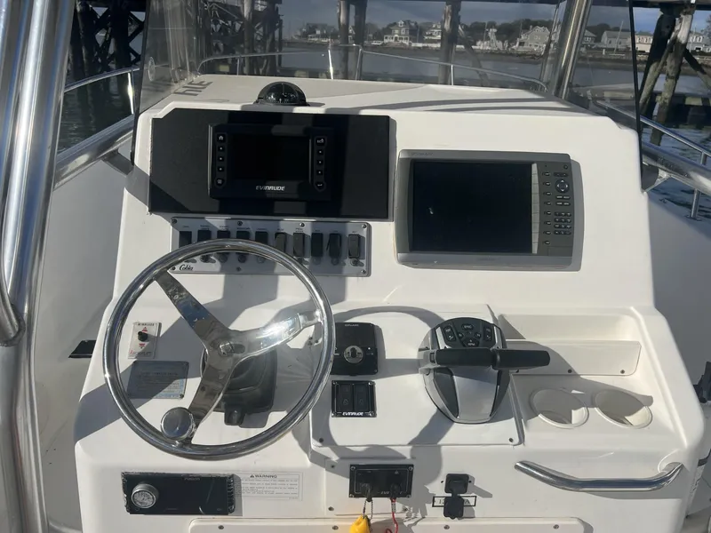 Slide: The Image of 2005 Cobia 314 Center Console boat dashboard with steering wheel and navigation equipment. - 9
