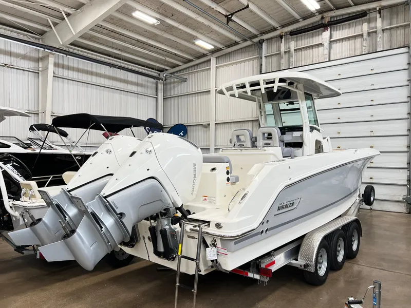 Slide: The Image of 2024 Boston Whaler 280 Outrage boat in a showroom, rear view. - 6
