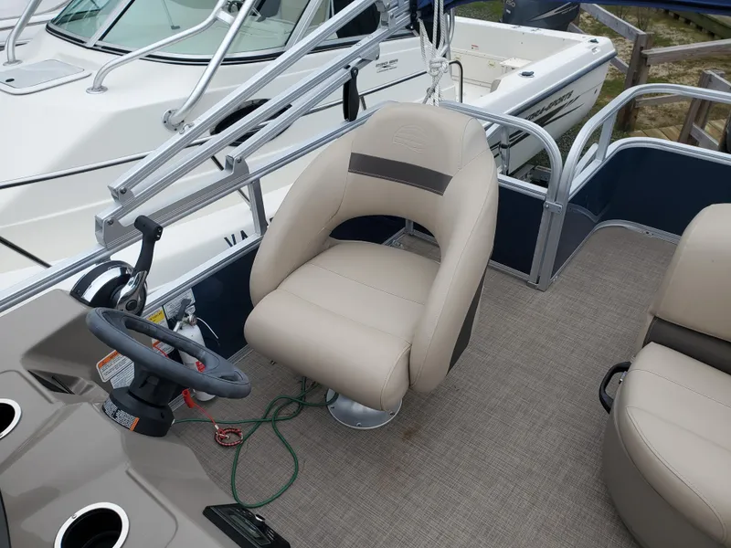 Slide: The Image of 2022 Sun Tracker Party Barge 18 DLX interior with steering wheel and seating. - 4