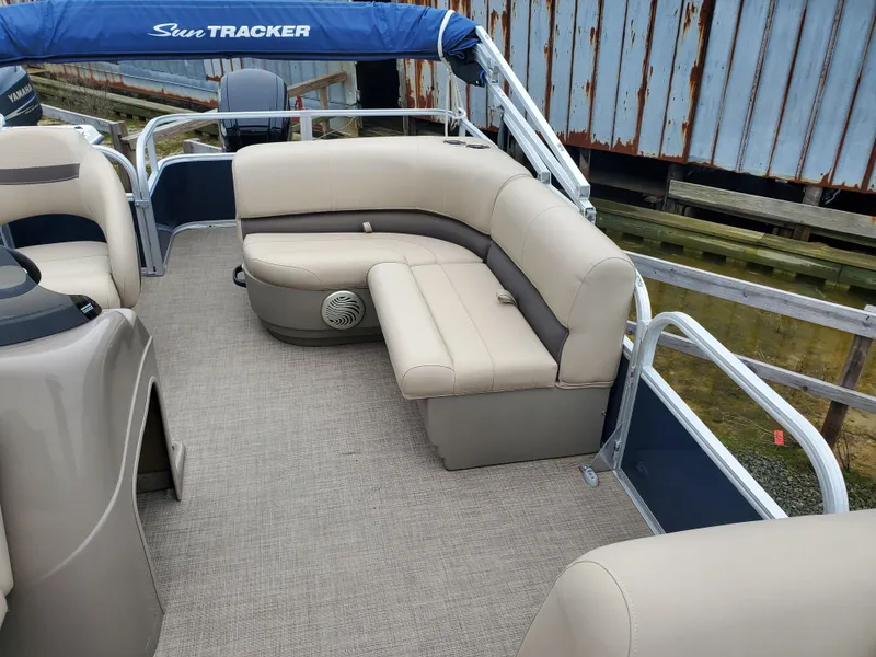 Slide: The Image of 2022 Sun Tracker Party Barge 18 DLX interior with beige seating and blue canopy. - 6