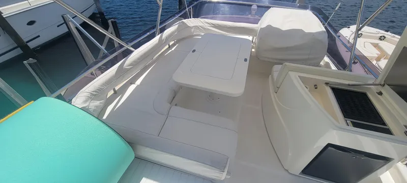 Slide: The Image of Luxurious 2009 Ferretti Yachts 470 flybridge with seating and table, docked by the water. - 17