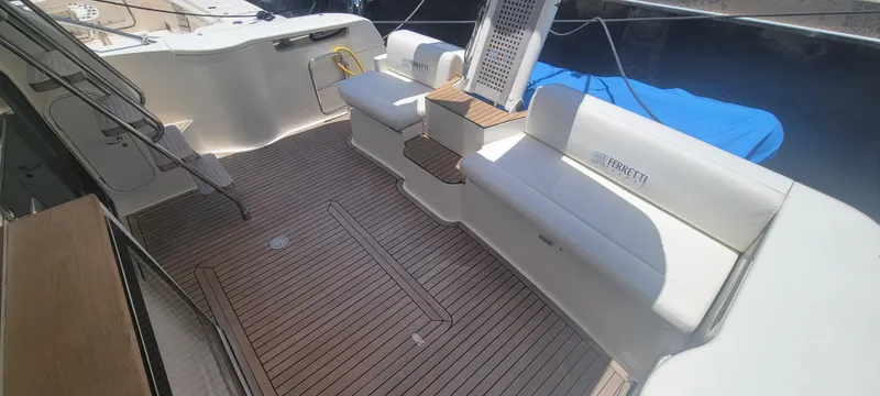 Slide: The Image of 2009 Ferretti Yachts 470 deck with white seating and wooden flooring. - 22