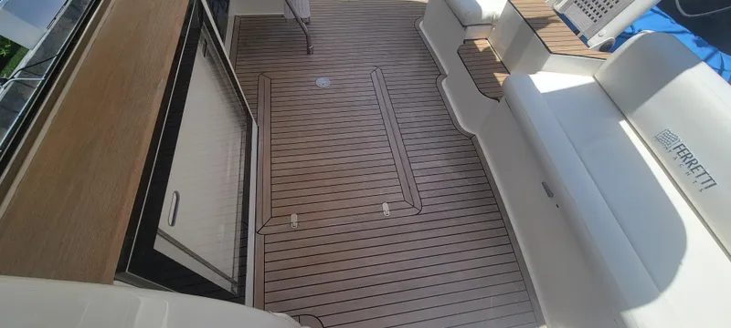 Slide: The Image of 2009 Ferretti Yachts 470 deck with wood flooring and white seating. - 23