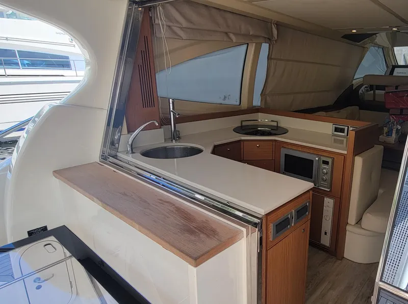 Slide: The Image of Interior of 2009 Ferretti Yachts 470, featuring a modern kitchen with wood accents. - 43