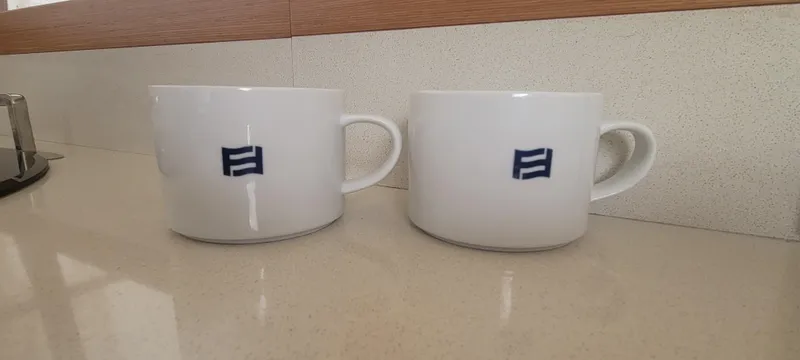 Slide: The Image of Two white mugs with blue logos on a countertop, Ferretti Yachts 470, 2009 model. - 46