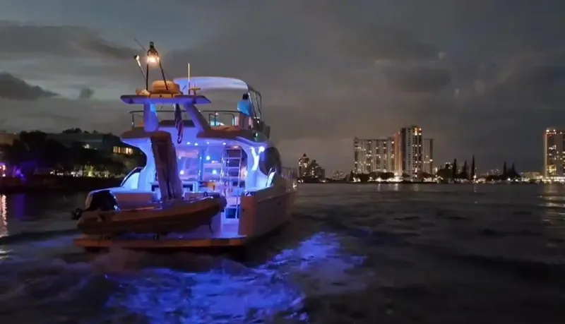 Slide: The Image of 2009 Ferretti Yachts 470 illuminated at night, cruising near city skyline. - 5