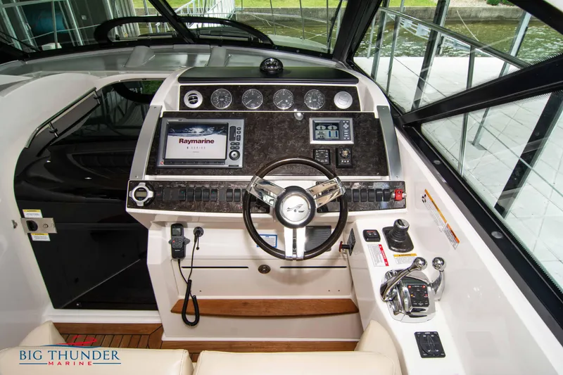 Slide: The Image of 2012 Sea Ray 410 Sundancer helm with advanced navigation controls and steering wheel. - 27