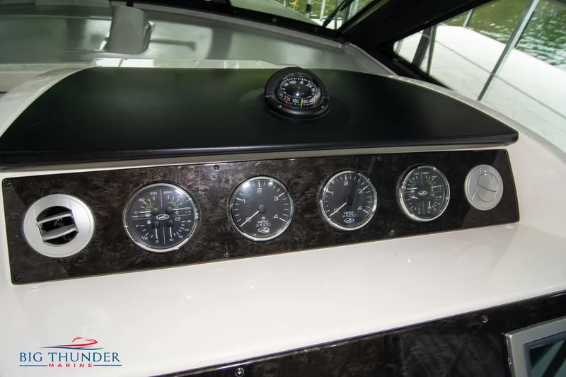 Slide: The Image of Dashboard of 2012 Sea Ray 410 Sundancer with gauges and compass, Big Thunder Marine logo. - 34