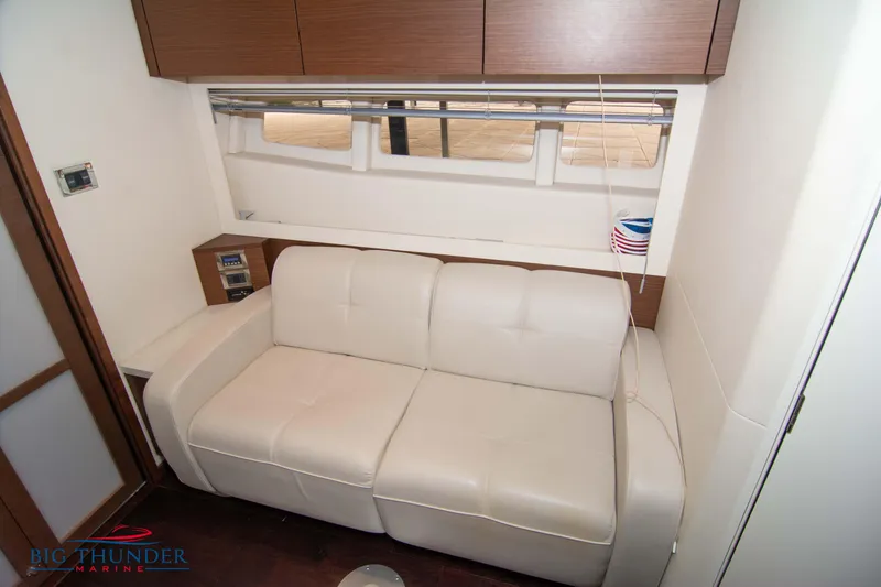 Slide: The Image of Interior of 2012 Sea Ray 410 Sundancer with white leather sofa and wooden cabinets. - 44