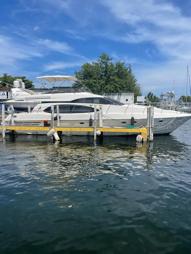 Slide: The Image of 2001 Azimut 58 yacht docked at a marina on a sunny day. - 2