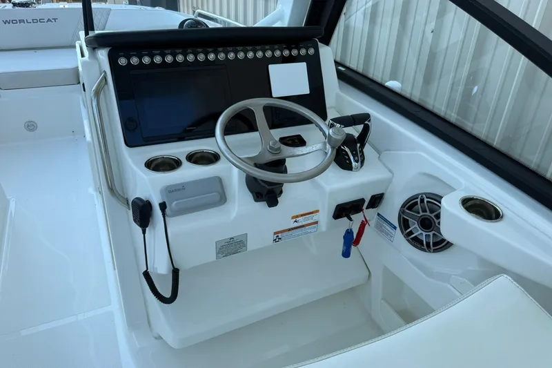 Slide: The Image of 2025 World Cat 260 DC-X boat helm with steering wheel and control panel. - 11