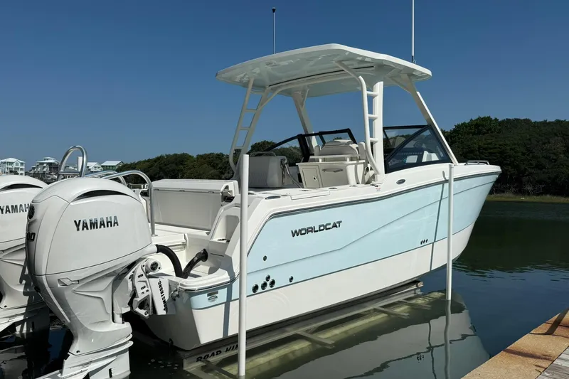 Slide: The Image of 2025 World Cat 260 DC-X boat with twin Yamaha engines docked on calm water. - 5