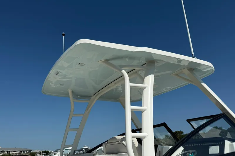 Slide: The Image of 2025 World Cat 260 DC-X boat with sleek hardtop and ladder under clear blue sky. - 6