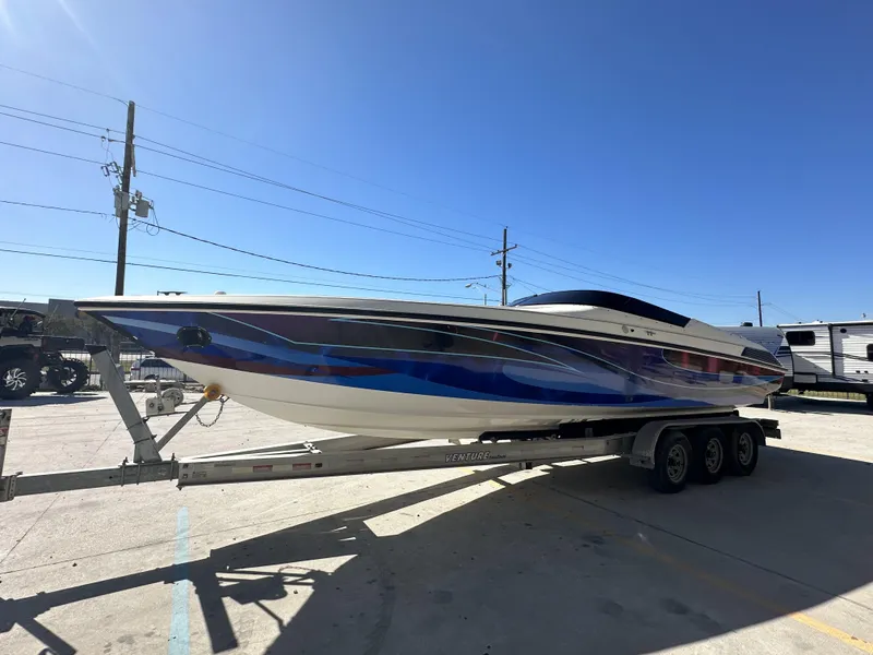 Slide: The Image of 1994 Wellcraft 2900 Sportboat on trailer, vibrant blue and white design, sunny day. - 10
