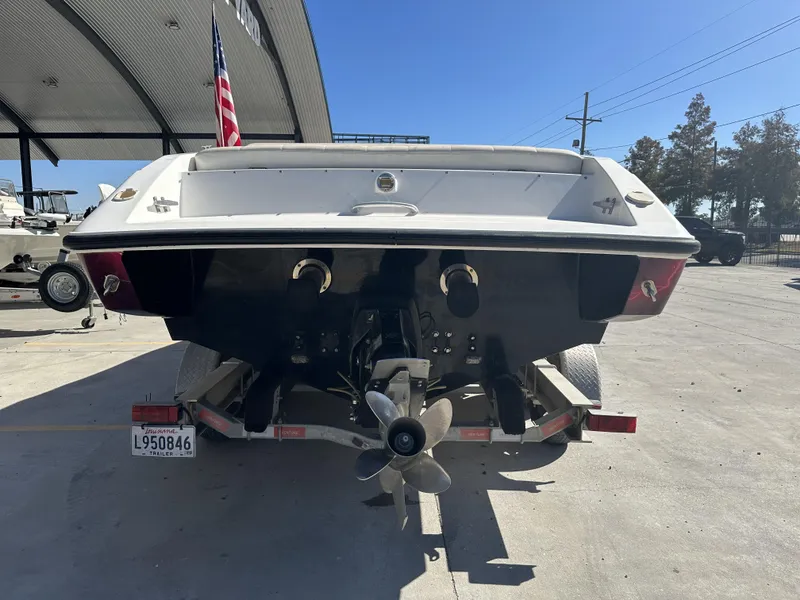 Slide: The Image of 1994 Wellcraft 2900 Sportboat on trailer, rear view with propeller and American flag. - 3