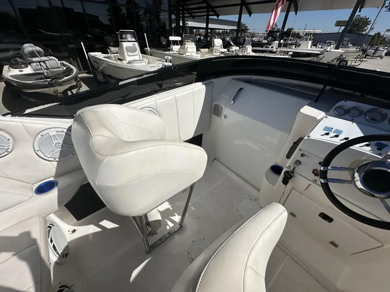 Slide: The Image of 1994 Wellcraft 2900 Sportboat cockpit with white seats and steering wheel. - 9