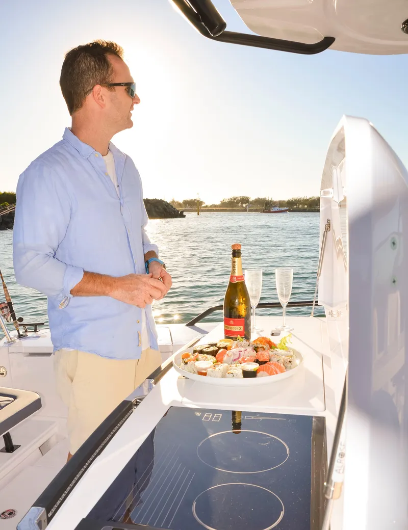 Slide: The Image of Man enjoying sushi and champagne on 2024 Axopar 37 Sun Top boat. - 5