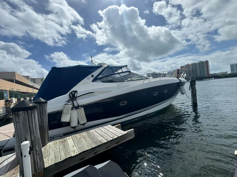 The Image of 2003 Sunseeker Portofino 46 yacht docked at marina under cloudy sky. - 0