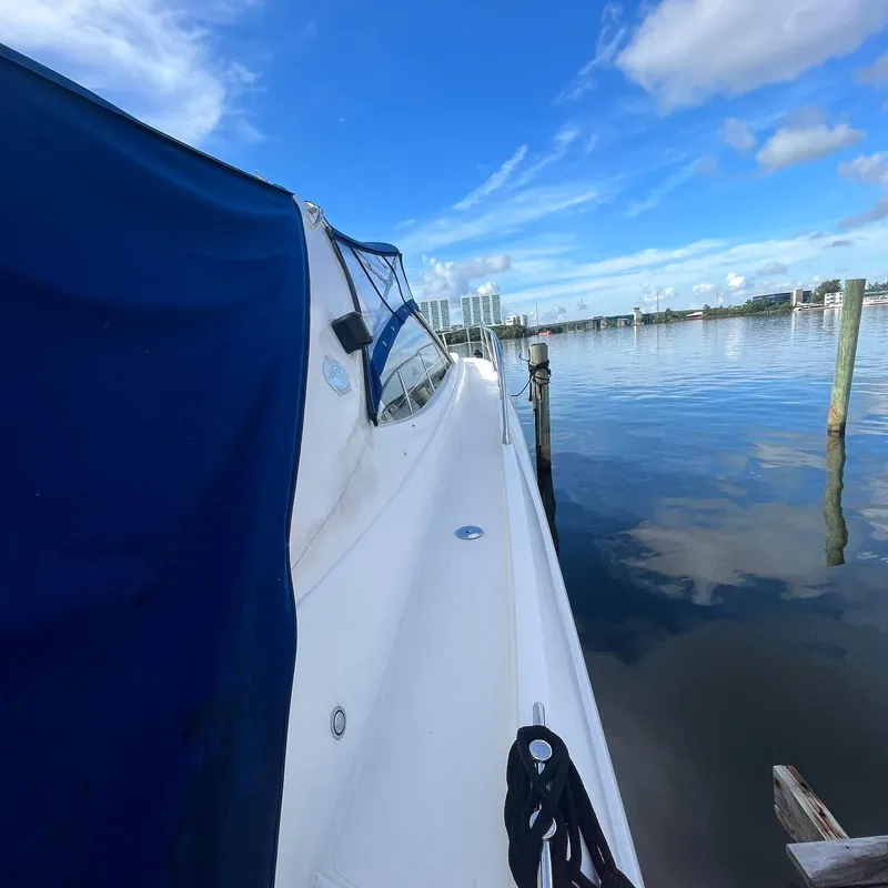 Slide: The Image of 2003 Sunseeker Portofino 46 yacht docked by calm waters under a blue sky. - 12