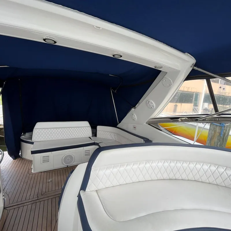 Slide: The Image of Interior of 2003 Sunseeker Portofino 46 yacht with white seating and blue canopy. - 24