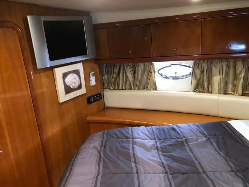 Slide: The Image of Sunseeker Portofino 46 2003 cabin interior with TV, bed, and porthole window. - 32