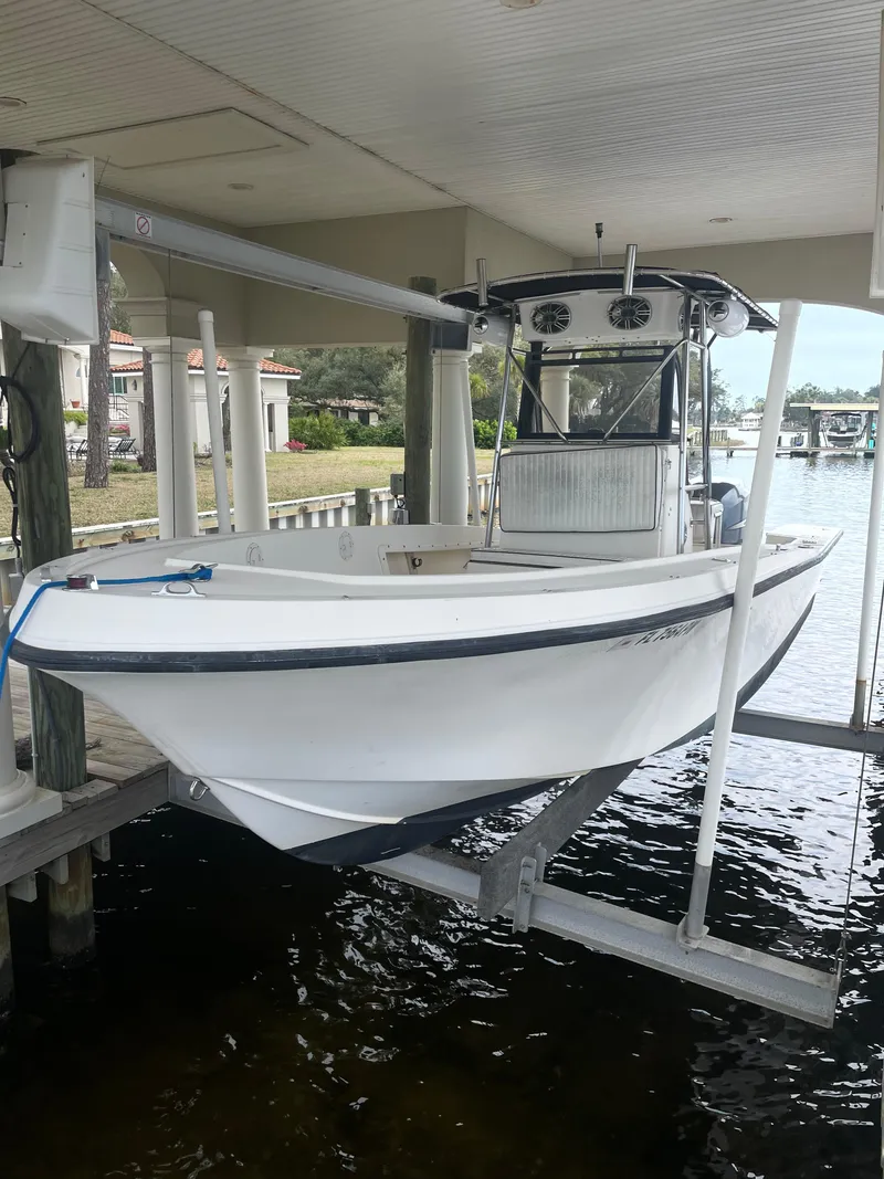 The Image of 1992 Mako 221 CC boat on a lift in a covered dock. - 1