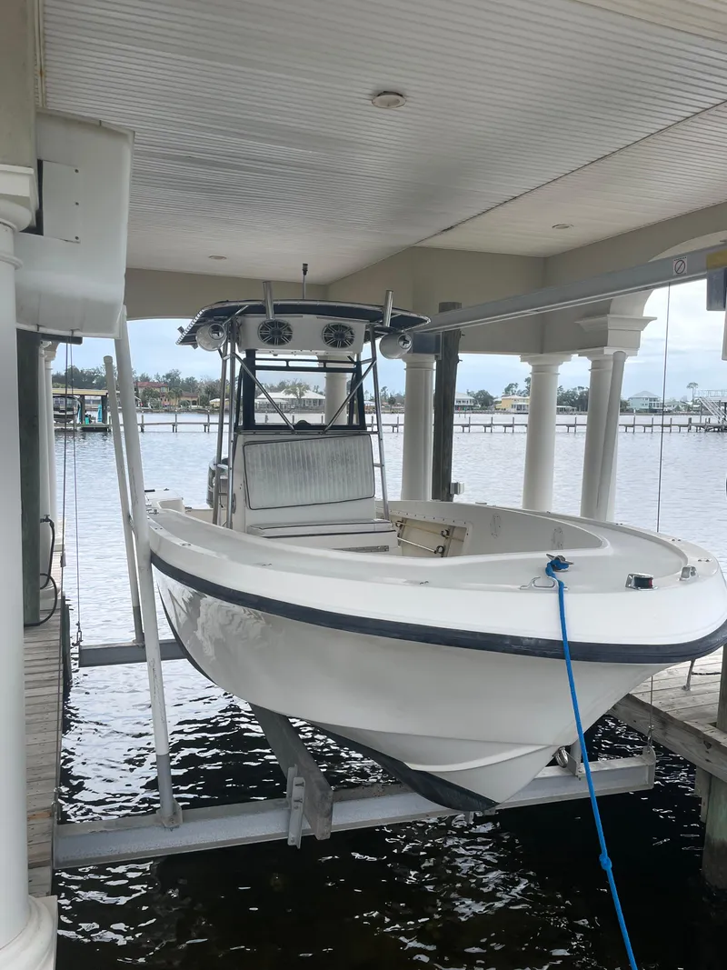 Slide: The Image of 1992 Mako 221 CC boat on a lift at a dock. - 2