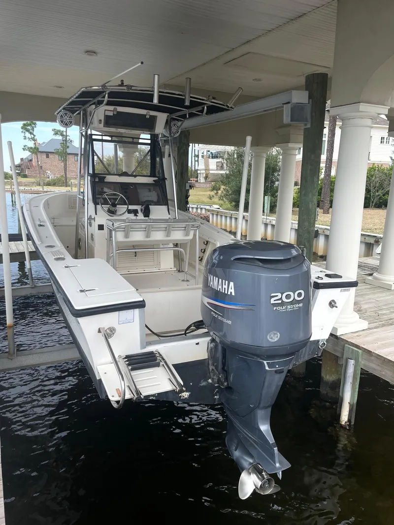 Slide: The Image of 1992 Mako 221 CC boat with Yamaha 200 outboard motor docked under a covered area. - 5