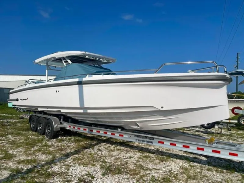 Slide: The Image of 2024 Axopar 37 Sun Top boat on trailer under clear blue sky. - 1