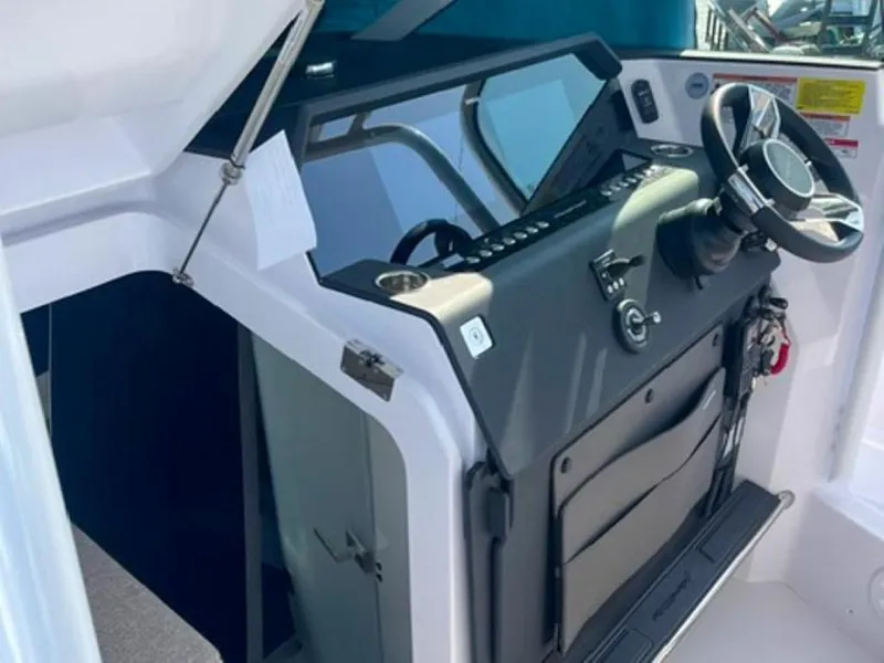 Slide: The Image of 2024 Axopar 37 Sun Top helm with modern steering and controls. - 7