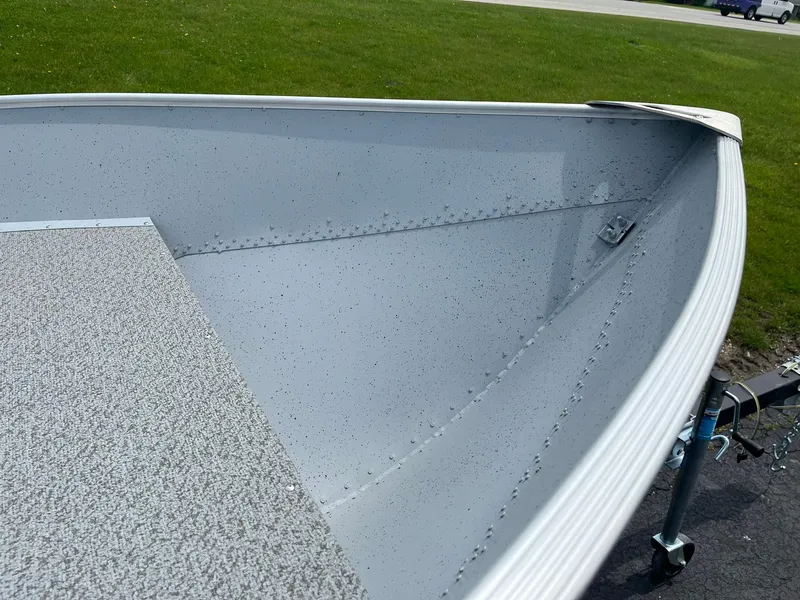 Slide: The Image of 2024 Lund WC-14 boat interior with gray textured flooring and aluminum hull. - 10