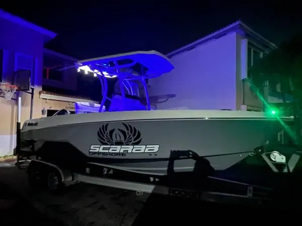 Slide: The Image of 2021 Wellcraft 222 Fisherman boat with Scarab Offshore branding at night. - 9
