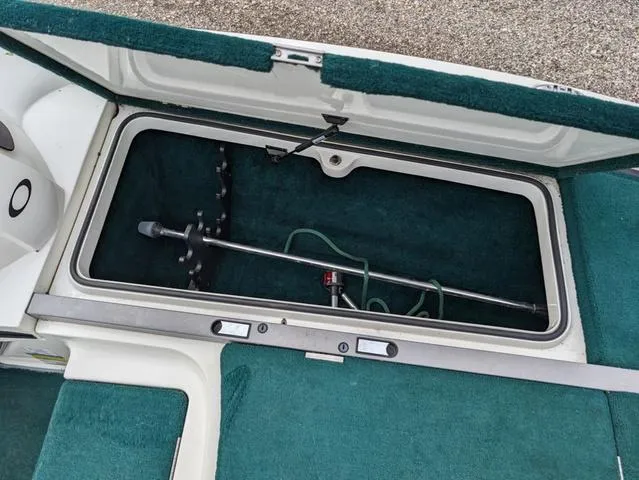 Slide: The Image of 2008 Ranger Comanche Z19 boat storage compartment with green carpet and fishing rod holder. - 10