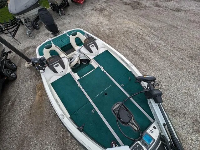 Slide: The Image of 2008 Ranger Comanche Z19 fishing boat with green interior, parked on gravel. - 7